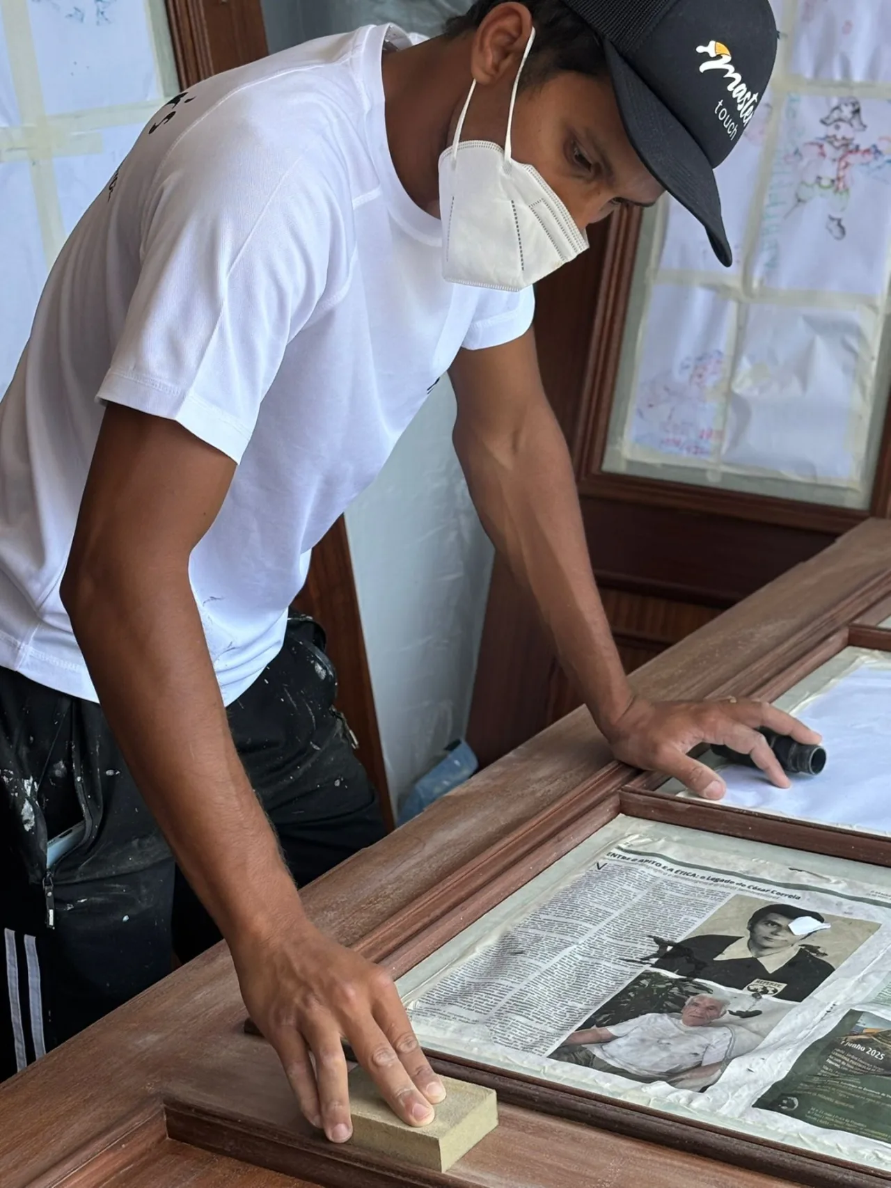 Hand-sanding the frame of a timber door before painting