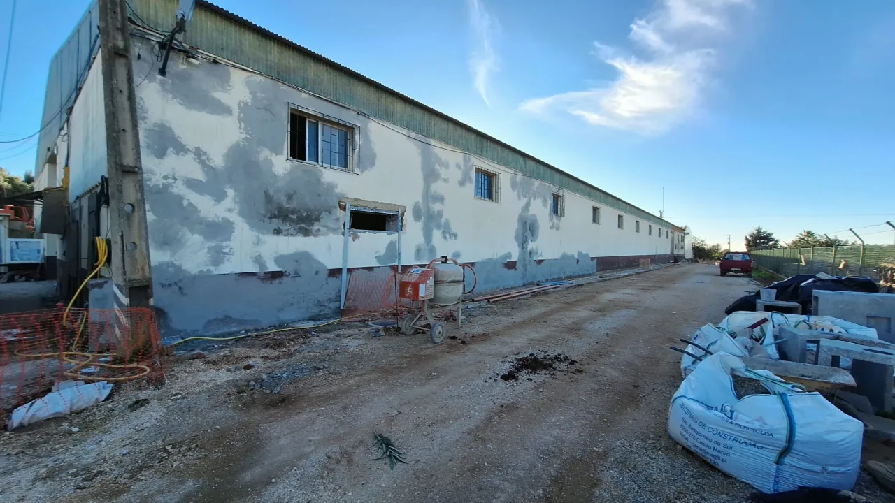 Warehouse exterior wall with the render repairs showing, during the work