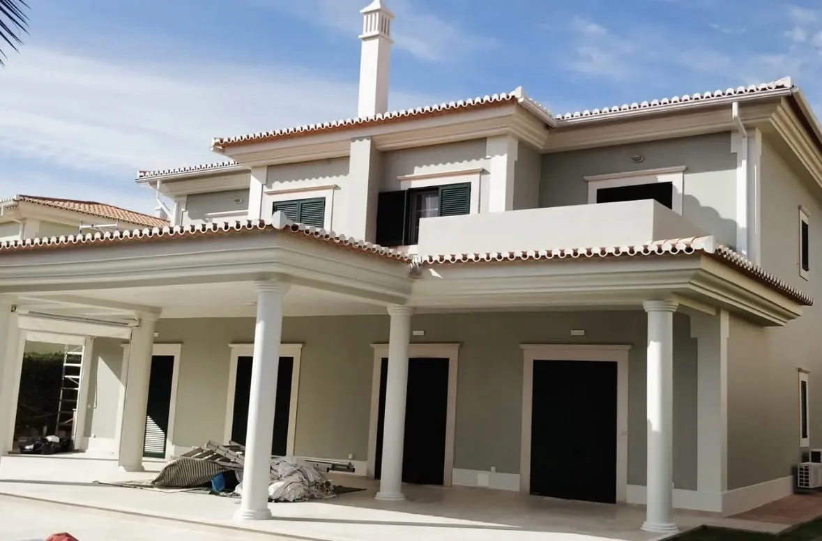 Two-storey villa in Quinta do Lago, with a white-columned porch and pale grey-green façades