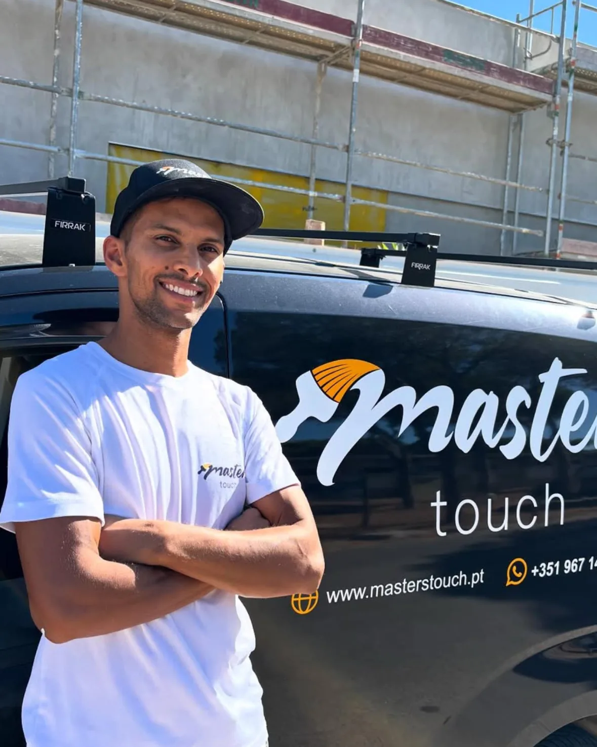 Geterson, in a Master's Touch cap and T-shirt, arms folded beside the company van